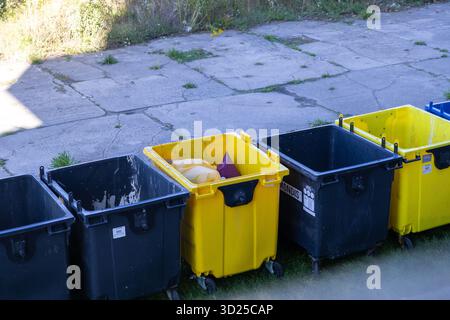 Poznan, Pologne - 24 septembre 2025 : MONDIS conteneurs de déchets municipaux et de recyclage, poubelles jaunes et foncées, illustrant le mana efficace des ordures publiques Banque D'Images