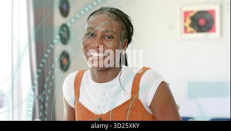 Femme souriante portant une chemise blanche sous un pull de rouille posant en studio, avec de l'art de disque vinyle Banque D'Images