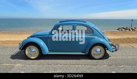 Classic Blue Volkswagen Beetle voiture à moteur garée sur la plage de promenade en bord de mer et la mer en arrière-plan. Banque D'Images