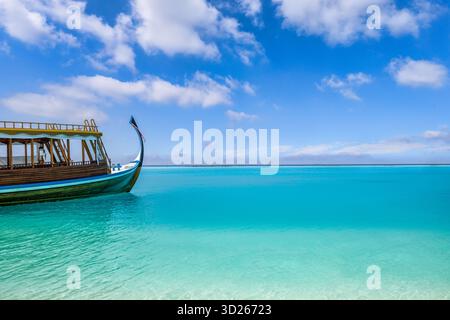 Maldives bateau en bois flottant dans la baie turquoise du lagon océanique pendant la saison ensoleillée de voyage d'été Banque D'Images