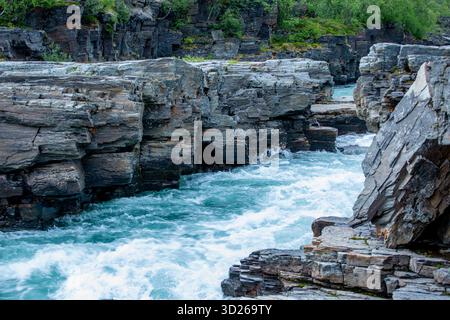 L'eau turquoise de la belle rivière Abisko, Abiskojokk, coule entre les rochers du canyon Abisko, Suède, Europe du Nord Banque D'Images
