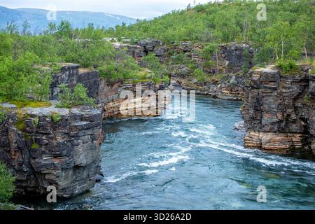 L'eau turquoise de la belle rivière Abisko, Abiskojokk, coule entre les rochers du canyon Abisko, Suède, Europe du Nord Banque D'Images