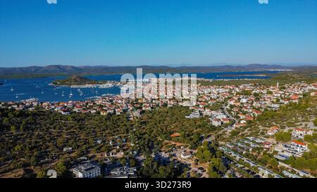 Ville côtière animée sur une péninsule, avec ses maisons au toit rouge s'étendant vers une marina animée remplie de bateaux. Banque D'Images