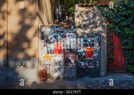 Erevan, Arménie 10.16.2025. Un mur avec beaucoup d'affiches dessus. Les affiches sont principalement sur la musique. Le mur est à côté d'une porte rouge Banque D'Images