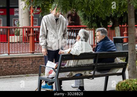 Skopje, Macédoine 12 octobre 2025 les retraités se sont rassemblés sur le banc avec un sac en plastique et de la verdure Banque D'Images