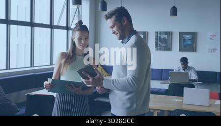 Collaborer des collègues examinant le dossier et la tablette au bureau de coworking, avec table en bois Banque D'Images