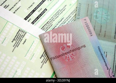 Le spécimen de carte de résident permanent temporaire allemand se trouve sur le formulaire fiscal allemand close up. Fiktionsbescheinigung et einkommensteuerklarung Banque D'Images