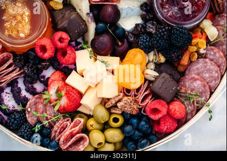 Gros plan de la charcuterie colorée avec viandes, fromages et fruits. Banque D'Images