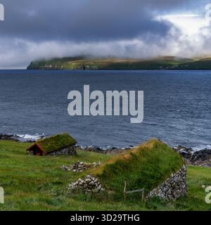 Une vue des maisons traditionnelles en pierre à toit de gazon dans le hameau de Skardanes sur l'île de Sandoy dans l'archipel des îles Féroé Banque D'Images