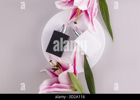 Des bouteilles de parfum noir et blanc mat avec une odeur naturelle de fraîcheur se trouvent sur un podium rond blanc. Un parfum pour vous et lui. Vue de dessus Banque D'Images