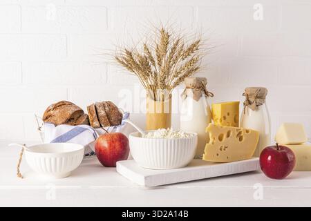 A produits laitiers frais, crème sure, fromage, lait, pommes à pain et épis de maïs dans un vase pour les vacances de Shavouot juif. Vue de face Banque D'Images