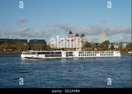 L'élégant bateau de croisière sur la rivière White « Viking Rolf » navigue sur le Rhin et passe devant la basilique historique de Kunibert et le paysage urbain de l'automne Banque D'Images