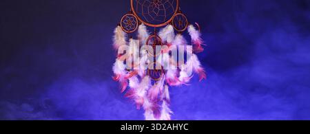 Attrapeur de rêve avec des plumes en fumée sur fond bleu. Conception de bannière Banque D'Images
