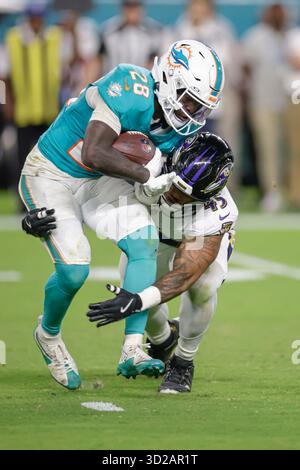 Miami Gardens, FL USA ; Miami Dolphins Running Back de'von Achane (28) court avec le ballon et affronté par le linebacker des Baltimore Ravens Mike Green (45) dans le troisième quart-temps lors d'un match de la NFL le jeudi 30 octobre 2025 au Hard Rock Stadium. Les Ravens ont battu les Dolphins 28-6. (Kim Hukari/image du sport) Banque D'Images