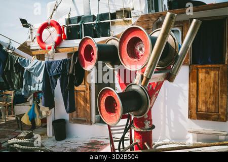 Bobines rouges pour le transport de filets de pêche sur un bateau de pêche dans le port de Parikia, Paros, Grèce Banque D'Images