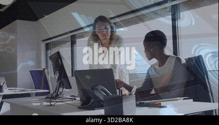 Collaboration de deux femmes d'affaires examinant l'écran d'ordinateur portable dans le bureau moderne, avec des ordinateurs portables, téléphone Banque D'Images