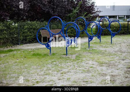 Parc de dressage de chiens en plein air moderne avec cerceaux d'agilité bleus et banc, conçu pour l'exercice et l'obéissance. Mode de vie sain et loisirs en plein air Banque D'Images