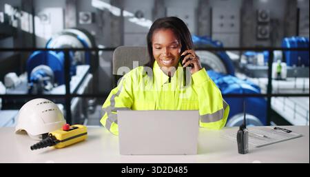 Une femme ingénieur africaine inspecte une centrale électrique avec un ordinateur portable. Banque D'Images