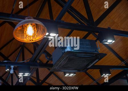 Climatiseur carré moderne monté au plafond noir. Dans un café moderne, il y a de la place pour le texte. Banque D'Images