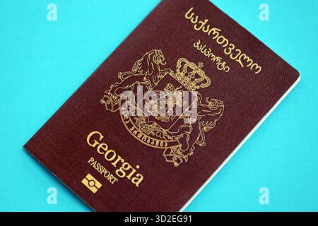 Livre de passeport géorgien sur fond de papier bleu clair gros plan. Document de voyage sur surface bleue Banque D'Images