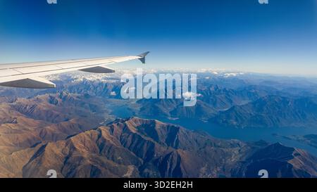 Vidéo aérienne panoramique montrant le Lago Maggiore et le paysage montagneux pris depuis la fenêtre de l'avion par temps clair Banque D'Images