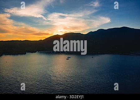 Alors que la première lumière de l'aube se lève sur Haïti, un paysage de lever de soleil à couper le souffle se déploie : les rayons dorés traversent l'horizon, projetant une lueur chaude à travers le Banque D'Images