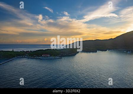 Alors que la première lumière de l'aube se lève sur Haïti, un paysage de lever de soleil à couper le souffle se déploie : les rayons dorés traversent l'horizon, projetant une lueur chaude à travers le Banque D'Images