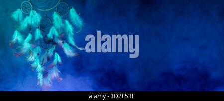 Attrapeur de rêve avec des plumes en fumée sur fond bleu. Conception de bannière Banque D'Images
