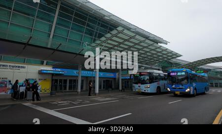SÉOUL, CORÉE DU SUD - 11 OCTOBRE 2025 - bus et voyageurs attendant devant le bâtiment moderne de l'aéroport international d'Incheon Banque D'Images