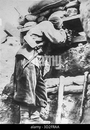 Tirée du miroir, octobre 1915, cette photographie représente un Spahi marocain tirant son fusil à travers une faille de tranchée pendant la première Guerre mondiale. Vêtu d’éléments uniformes traditionnels, il démontre la transformation de la cavalerie en chasseurs de tranchées. Les Spahis, originaires d'Afrique du Nord, sont réputés pour leur bravoure et sont intégrés aux côtés de l'infanterie française. Cette image reflète à la fois l'implication coloniale et la nature statique et broyante de la guerre de tranchées moderne en 1915. Banque D'Images