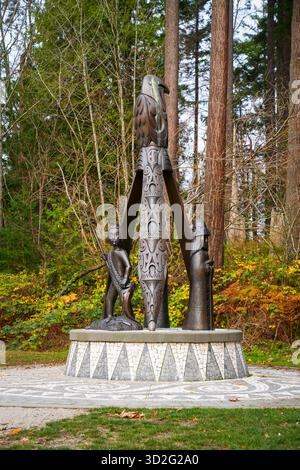 La sculpture Shore to Shore du parc Stanley, représentant des personnages honorant les Salish de la côte et le patrimoine portugais, se dresse contre la forêt environnante Banque D'Images