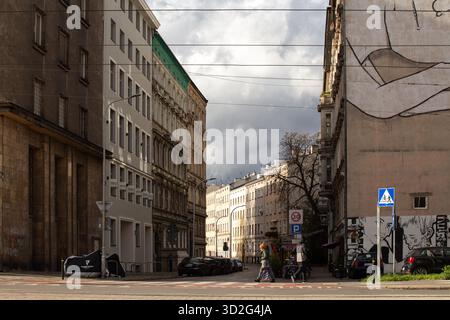 Scène de rue de ville montrant des bâtiments et des piétons par temps nuageux Banque D'Images