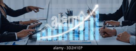 L'équipe commerciale participe à une réunion, analysant les données de croissance affichées sur un ordinateur portable. L'image reflète la collaboration, la stratégie et le professionnalisme dans un Banque D'Images
