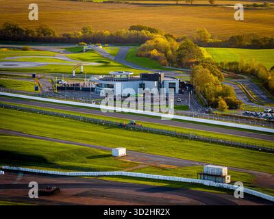 Vue aérienne du circuit de Silverstone à la lumière du petit matin, avec les tribunes, les bâtiments de fosse et le tracé des pistes. Idéal pour les thèmes du sport automobile Banque D'Images