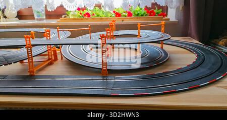 Vue partielle d'une piste privée de voitures à sous avec des sections de pont surélevées, créant une scène de course miniature dynamique. Banque D'Images