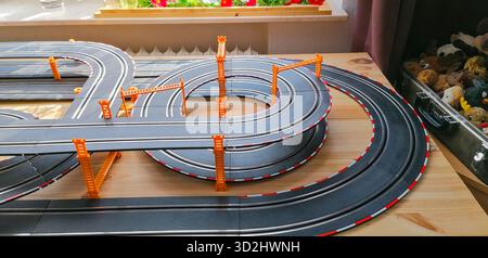 Vue partielle d'une piste privée de voitures à sous avec des sections de pont surélevées, créant une scène de course miniature dynamique. Banque D'Images