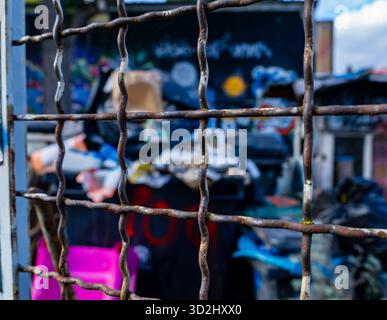Gros plan d'une grille métallique rouillée devant un site d'élimination illégale de déchets à Berlin, en Allemagne. Banque D'Images