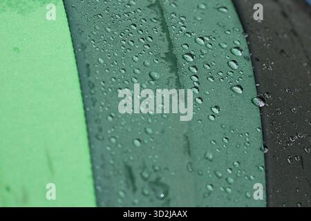 Petite gouttelette d'eau surface verte vibrante, montrant la texture rafraîchissante de la pluie. vue macro de la nature liquide artistique, créant serein et captivant a Banque D'Images