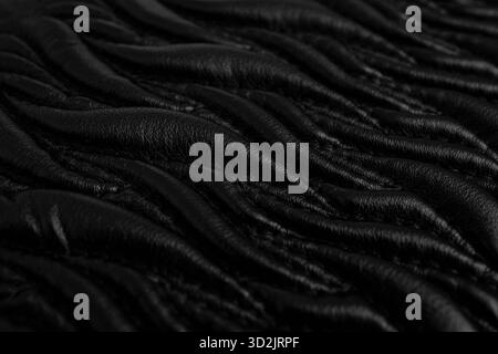 Motif abstrait avec des points sur cuir noir, formes de flamme ornementales sur un nouveau sac à main, soft focus close up Banque D'Images