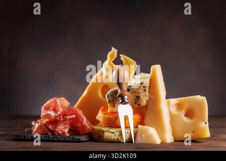 Fromages assortis de différentes formes et textures affichés ensemble sur une surface rustique Banque D'Images