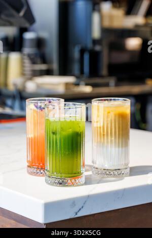 Limonades d'été assorties dans des pots en verre avec des fruits frais, de la glace et des garnitures colorées Banque D'Images