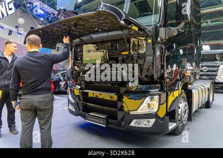 MINSK, BIÉLORUSSIE - 3 JUIN 2025 : un semi-camion Dongfeng GX avec cabine ouverte est exposé au salon de l'auto de 2025. Deux hommes regardent le tru Banque D'Images