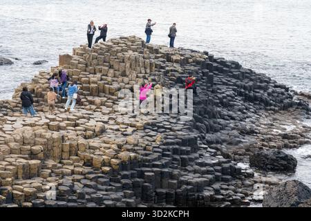 Visiteurs visitant la chaussée des géants, un site classé au patrimoine mondial de l'UNESCO près de Bushmills, Irlande du Nord. Banque D'Images