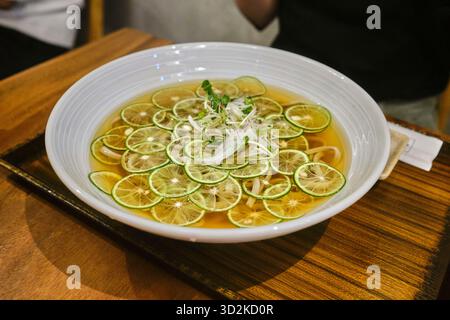 Un bol de soba sudachi, nouilles de sarrasin avec des agrumes japonais rafraîchissants dans un bouillon léger et acidulé Banque D'Images