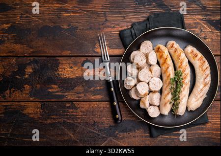 Saucisses grillées avec de la viande de forçage mincemat et des herbes dans l'assiette. fond en bois. vue de dessus. Banque D'Images