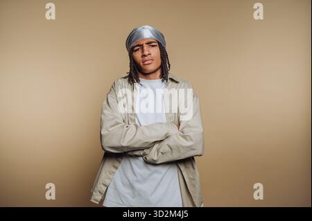 Jeune homme avec un durag et une tenue décontractée croisant les bras. Banque D'Images