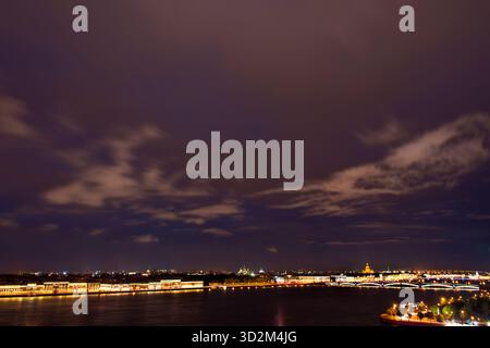Une vue panoramique de la ligne d'horizon de Saint-Pétersbourg (préparé Petersburg) à travers la rivière Neva la nuit, avec des bâtiments illuminés et des ponts sous un Banque D'Images