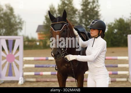Cheval de dressage et cavalier de jockey en uniforme portrait lors du spectacle de compétition de saut équestre Banque D'Images