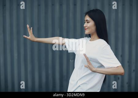 Jeune femme asiatique faisant qigong wushu Taijiquan exercice d'été en plein air Banque D'Images