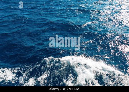 Vagues bleues vibrantes de l'océan et reflets de la lumière du soleil créant une scène nautique dynamique. Banque D'Images